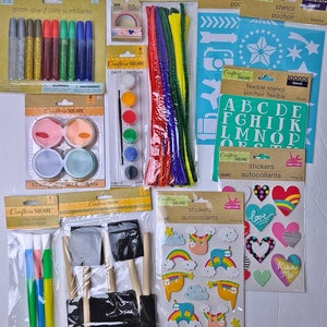 Pu&ograve; includere: Una collezione di materiali per l'artigianato, tra cui colla glitterata, vernice, scovolini, stencil, adesivi, nastro adesivo e pennelli. Gli articoli sono confezionati e pronti per progetti creativi. I colori includono argento, oro, rosso, verde, blu, rosa e nero.