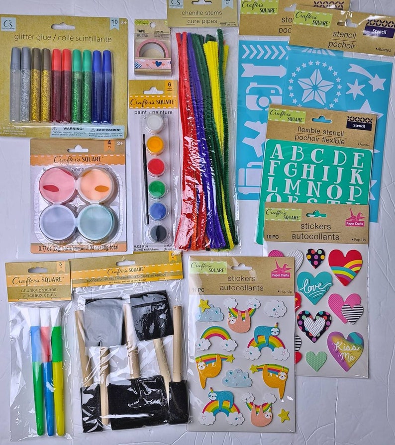 Pu&ograve; includere: Una collezione di materiali per l'artigianato, tra cui colla glitterata, vernice, scovolini, stencil, adesivi, nastro adesivo e pennelli. Gli articoli sono confezionati e pronti per progetti creativi. I colori includono argento, oro, rosso, verde, blu, rosa e nero.