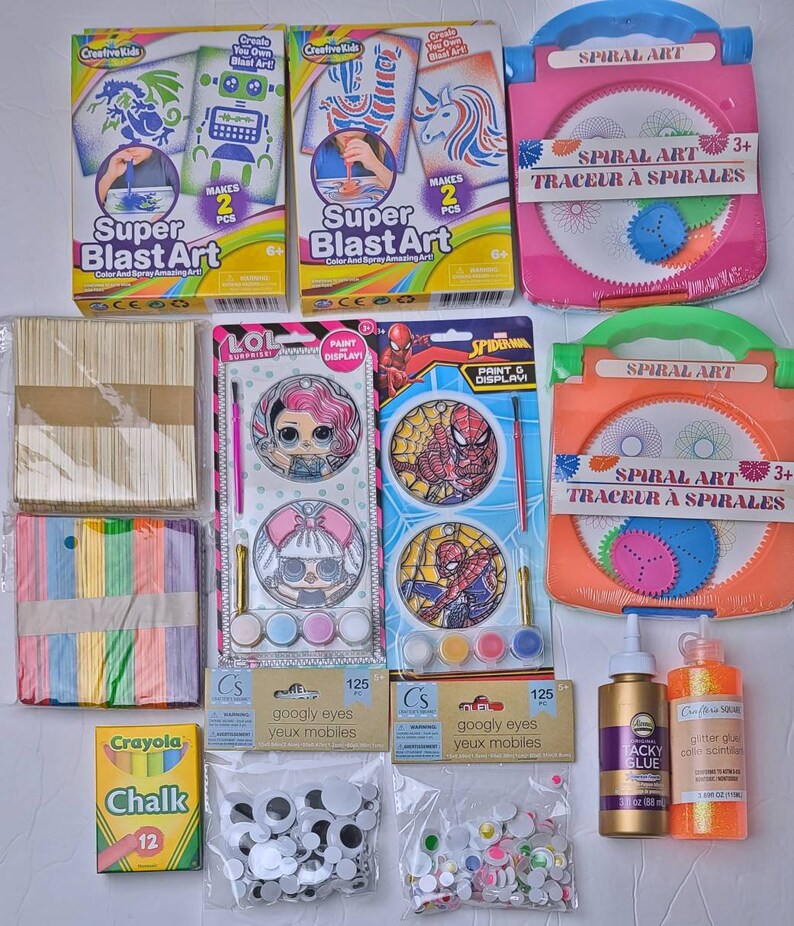 Pu&ograve; includere: Una collezione di materiali artistici per bambini, tra cui kit Super Blast Art, set Spiral Art, kit di pittura, occhi mobili, colla, colla glitterata e gessetti Crayola. Gli articoli sono disposti su una superficie bianca.