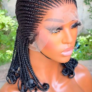 Könnte beinhalten: Eine schwarze geflochtene Perücke mit einem Spitzenfront. Die Perücke ist in einem Cornrow-Muster gestylt, wobei die Zöpfe am Hinterkopf herunterhängen.