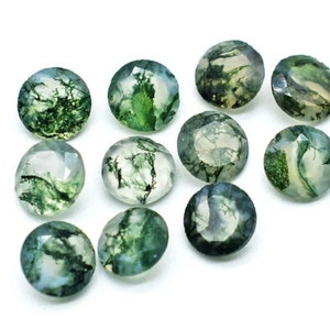May include: A collection of 10 round, green moss agate cabochons. The stones have a variety of green and white patterns.