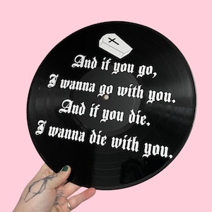 May include: Black vinyl record with white text that reads "And if you go, I wanna go with you. And if you die, I wanna die with you." A small white coffin with a cross is at the top of the record.