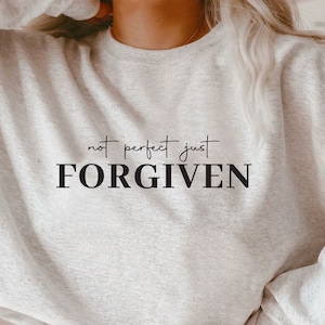 Könnte beinhalten: Ein graues Sweatshirt mit dem Aufdruck "not perfect just FORGIVEN" auf der Vorderseite.