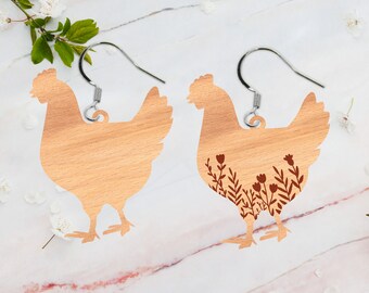 May include: A pair of wooden chicken earrings. One earring is plain wood, while the other has a brown floral design.