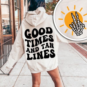 May include: A white hoodie with a black graphic that says "Good Times and Tan Lines".