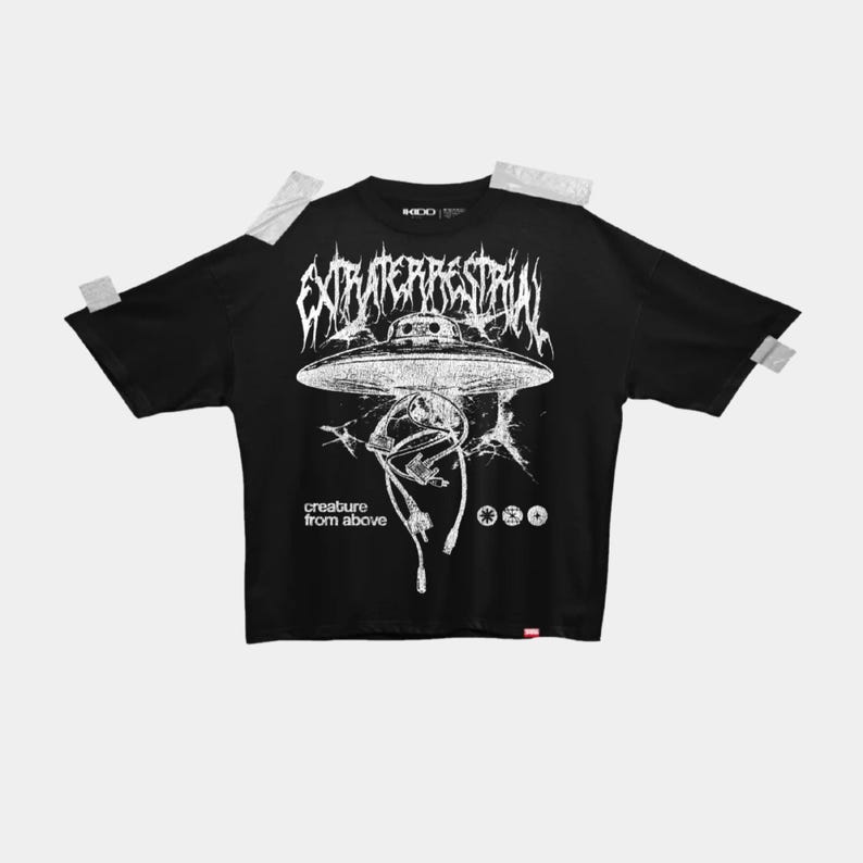 May include: Black t-shirt with a white graphic of a UFO and alien figure. The text "EXTRATERRESTRIAL" is above the UFO, and "creature from above" is below. The shirt has a crew neck and short sleeves.