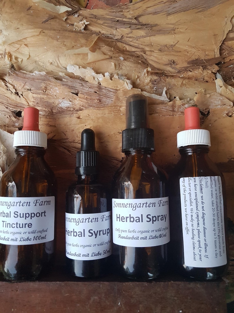 May include: Three glass bottles with dropper tops containing herbal tinctures and sprays. The bottles are labelled "Sonnengarten Farm" and feature the text "Herbal Support Tincture", "Herbal Syrup", and "Herbal Spray".