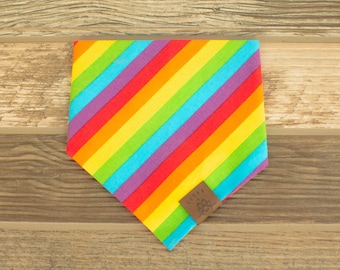 Può includere: Bandana per cani a righe arcobaleno con un'etichetta in pelle marrone che dice "Little Paw Prints".