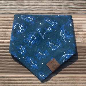 May include: A dark blue bandana with a white constellation pattern featuring the zodiac signs. The bandana has a brown leather tag with the word "SOUL" printed on it.
