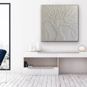 May include: A white textured canvas painting of a tree with a white background. The tree is made up of small white dots and lines.