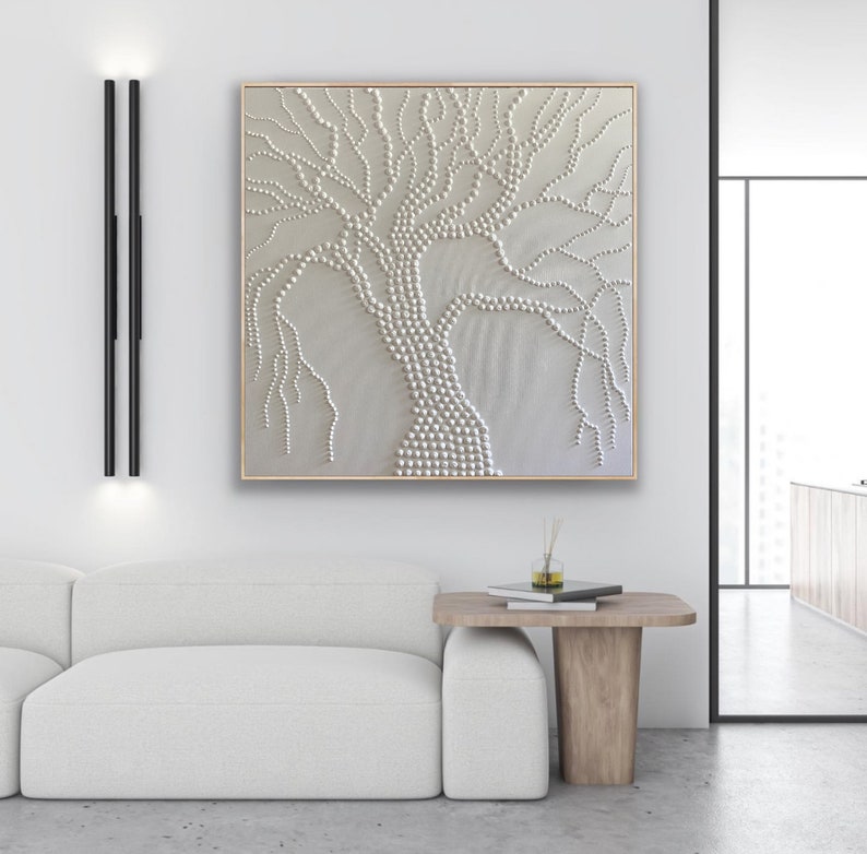 May include: A white textured canvas painting of a tree with a white background. The tree is made of small white circles and has a thick trunk and branches.