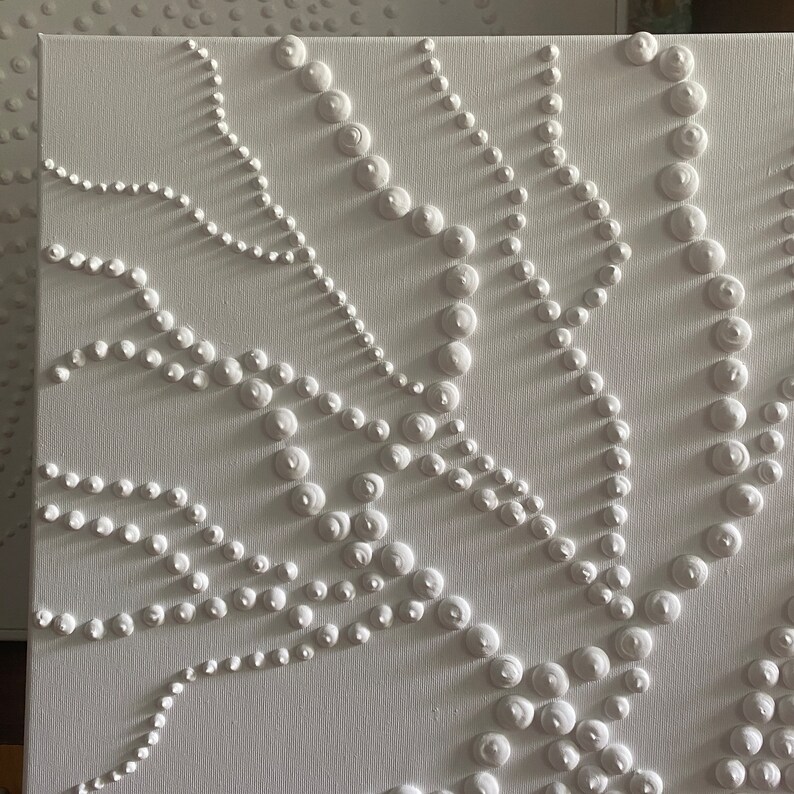 May include: White canvas painting with a raised, textured design of white circles in a repeating pattern.