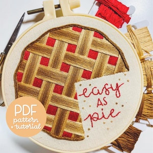 May include: Embroidered hoop art featuring a red and brown pie design with the text "easy as pie".