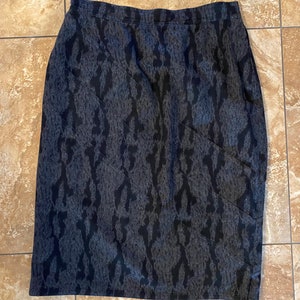 May include: A gray skirt with a black animal print pattern.
