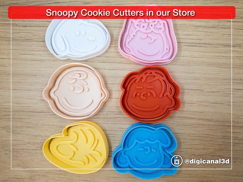 Puede incluir: Conjunto de seis cortadores de galletas de pl&aacute;stico de colores con forma de diferentes personajes de la tira c&oacute;mica Peanuts. Los cortadores est&aacute;n dispuestos sobre una superficie de madera. Los personajes incluyen Snoopy, Woodstock, Charlie Brown, Lucy, Linus y Sally.