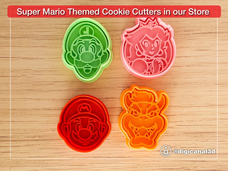Puede incluir: Cuatro cortadores de galletas de pl&aacute;stico con forma de personajes de la franquicia de videojuegos Super Mario. Los cortadores son verdes, rosas, rojos y naranjas. Los personajes son Luigi, la princesa Peach, Mario y Bowser.
