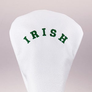 Puede incluir: Cubierta blanca para la cabeza de un palo de golf con el texto "IRISH" bordado en verde.