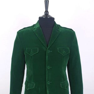 May include: A dark green velvet blazer with four buttons and two flap pockets.