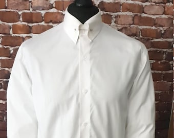 Puede incluir: Una camisa blanca de manga larga con cuello abotonado y una barra de cuello. La camisa tiene un corte clásico y está hecha de una tela suave y resistente a las arrugas.