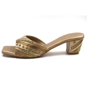 May include: Gold heeled sandals with a square toe and intricate beaded embellishments.