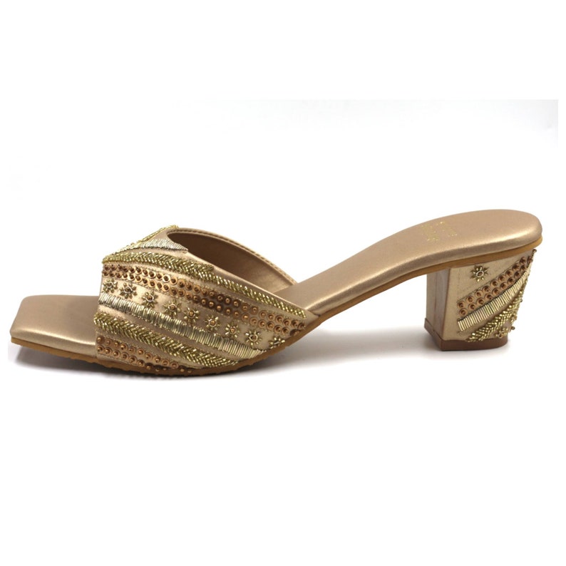 May include: Gold heeled sandals with a square toe and intricate beaded embellishments.