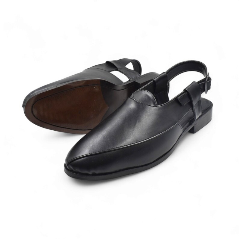 May include: A pair of black leather slip-on shoes with a slingback strap. The shoes have a pointed toe and a low heel.