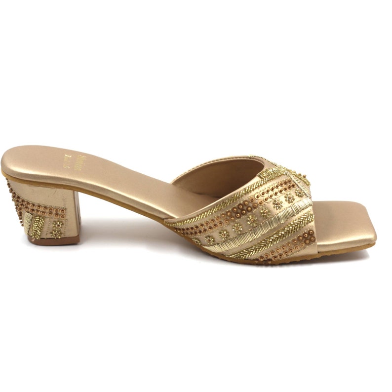 May include: Gold heeled sandals with a square toe and intricate beaded embellishments.