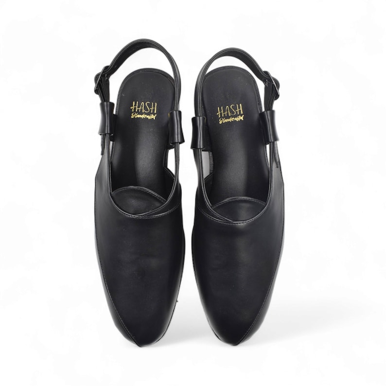 May include: A pair of black leather slip-on shoes with a slingback strap. The shoes have a pointed toe and the brand name "HASH" is printed on the insole.