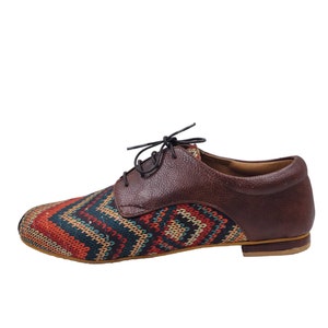 Puede incluir: Zapatos de cordones de cuero marr&oacute;n y tela estampada con suela marr&oacute;n.