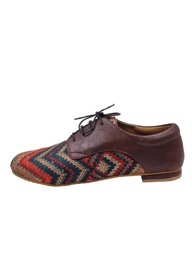Puede incluir: Zapatos de cordones de cuero marr&oacute;n y tela estampada con suela marr&oacute;n.