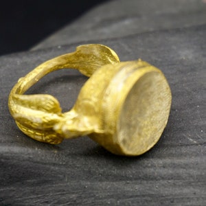 An antique Afghan-inspired brass ring , with a round head