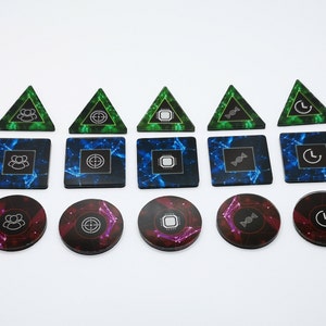 May include: A set of 10 green, blue, and purple game tokens with different symbols. The tokens are in the shape of triangles and circles. The symbols include a person, a target, a computer chip, a DNA strand, and a clock.