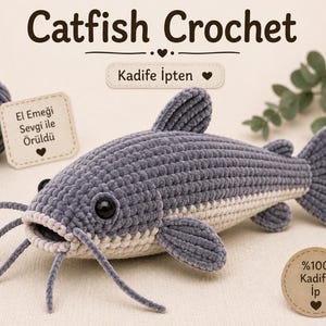 May include: A gray and cream-colored crochet catfish plush toy with black eyes and long whiskers. The text reads Catfish Crochet, Kadife İpten, El Emeği Sevgi ile Örüldü, and %100 Kadife İp. A ball of gray yarn is visible in the upper left corner.