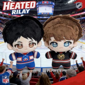May include: Two plush dolls with anime-style features, one in a blue and red hockey jersey, the other in a black and red jersey. The dolls have large eyes and fluffy hair. The text "HEATED RILAY" is above them.