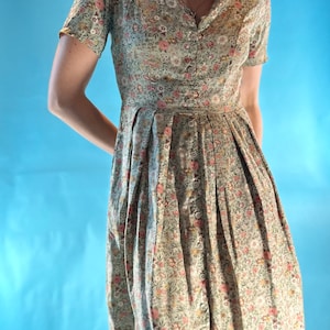 Vintage 1950s Pastel Ditsy Floral Printed Short Sleeve V Neck Pleated Midi Tea Dress with Tie Back Detail.