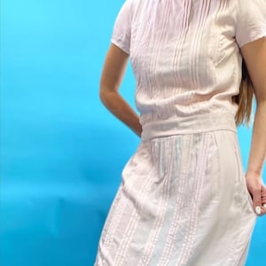 Hellrosa knielanges Kleid mit Pin-Tuck-Falten und angeschnittenen Ärmeln.
