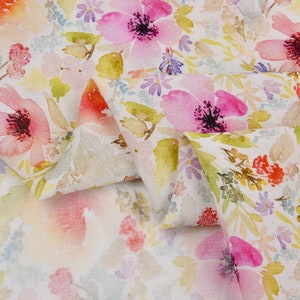 Peut inclure: Tissu blanc avec un imprim&eacute; floral aquarelle repr&eacute;sentant des fleurs roses, rouges et jaunes. Le tissu est pli&eacute; en deux, montrant le motif des deux c&ocirc;t&eacute;s.