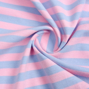 May include: Close-up of a pink and blue striped fabric. The fabric is soft and has a subtle texture.