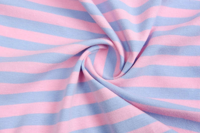 May include: Close-up of a pink and blue striped fabric. The fabric is soft and has a subtle texture.