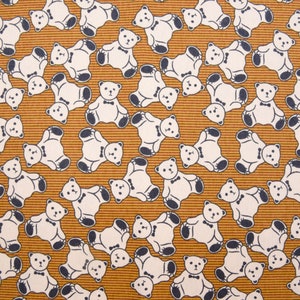 May include: A brown fabric with a repeating pattern of white teddy bears wearing bow ties. The bears are facing different directions and are arranged in a random pattern.