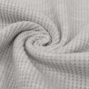 May include: Close-up of a light gray waffle-knit fabric. The fabric is tightly woven with a textured, grid-like pattern. The material is arranged in a swirling, spiral shape, showcasing its drape and texture. The fabric appears soft and pliable.