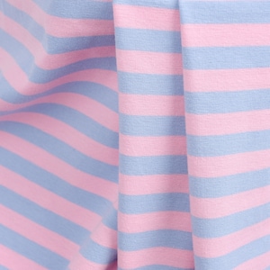 May include: Close-up of pink and blue striped fabric. The fabric is folded and wrinkled, showing the texture of the material.