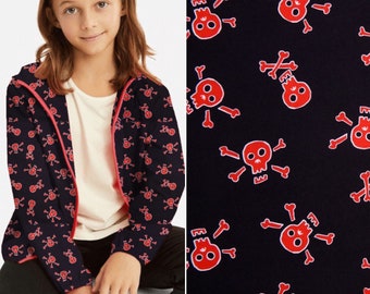 May include: A black zip-up jacket with a red skull and crossbones pattern. The jacket has a pink zipper and a hood.