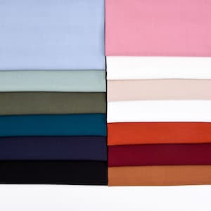 May include: A stack of fabric swatches in various colors, including light blue, green, teal, navy, black, orange, red, brown, and pink.