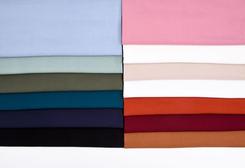 May include: A stack of fabric swatches in various colors, including light blue, green, teal, navy, black, orange, red, brown, and pink.