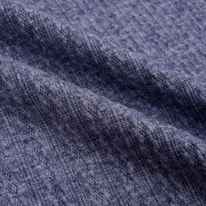 May include: Close-up of a blue knitted fabric with a textured surface.