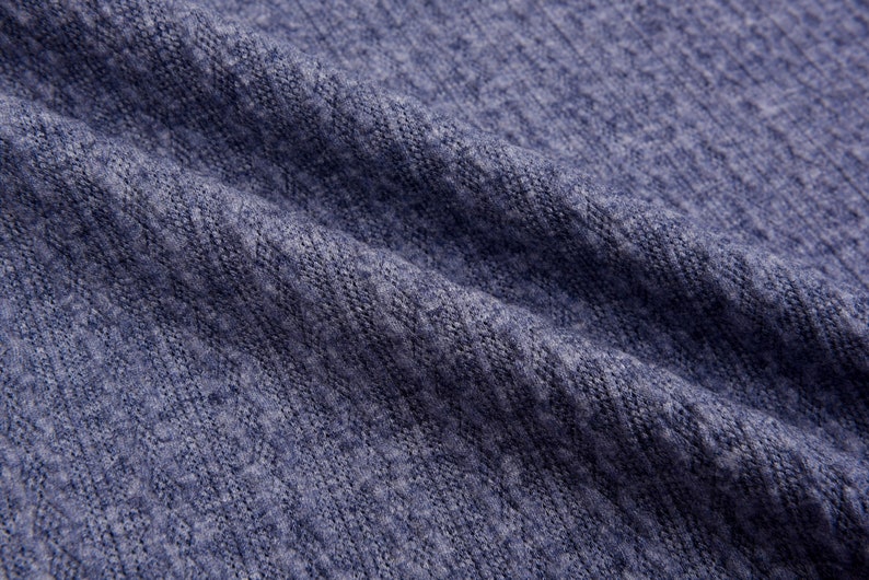 May include: Close-up of a blue knitted fabric with a textured surface.