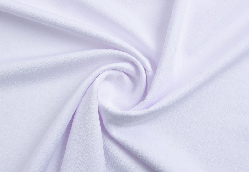 Pode incluir: Close-up de um tecido branco com textura lisa e dobras suaves.