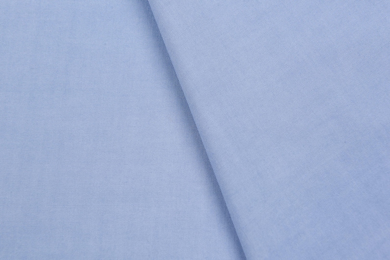 May include: A close-up of a light blue fabric with a smooth texture.