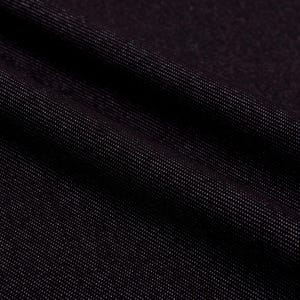 May include: Close-up of dark denim fabric with a subtle sheen. The fabric is a deep black color, with a diagonal weave pattern visible. The texture appears soft and pliable, with gentle folds and shadows.